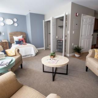 A cozy living and bedroom area with modern furniture and neutral decor.