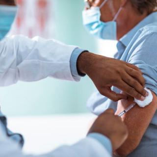 A healthcare professional administers a vaccine to a patient in a medical setting.