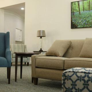 A cozy living room with a sofa, armchair, and decorative elements.