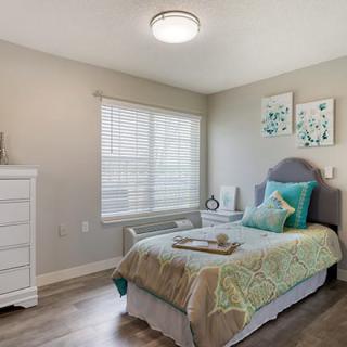 A stylish bedroom featuring a single bed with modern decor and ample natural light.