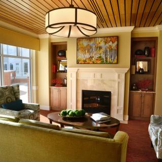 A cozy living room featuring a fireplace, elegant lighting, and comfortable seating arrangements.
