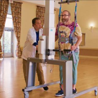 A person receiving support with a walking aid during rehabilitation therapy.