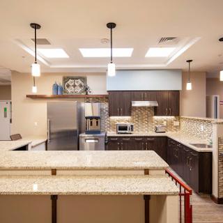 A modern kitchen featuring elegant granite countertops and contemporary appliances, illuminated by stylish pendant lights.