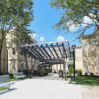 A welcoming entrance with a modern canopy surrounded by greenery.