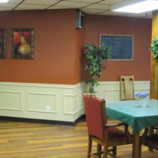 A cozy dining area with a table, chairs, and wall decorations.
