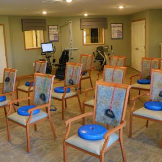 A rehabilitation area equipped with chairs and exercise equipment for physical therapy sessions.