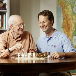 Two people enjoying a game of chess together at home.