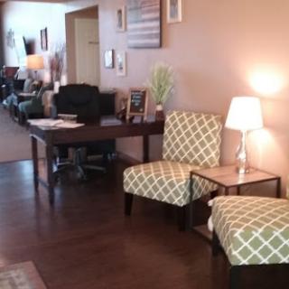 A cozy waiting area featuring stylish chairs and a table, creating a welcoming atmosphere.