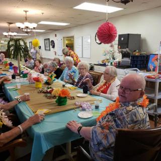 Seniors enjoying a vibrant community gathering with festive decorations and lively conversation.