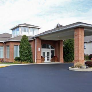 A brick building with a covered entrance, possibly a hotel or similar establishment.