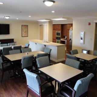 A spacious dining area in a community facility, featuring several tables and chairs.