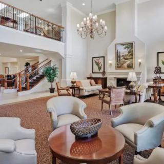 A spacious and elegant lobby with comfortable seating, a grand chandelier, and stylish decor.