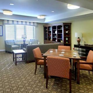 A cozy living room with comfortable seating, a wooden table, and a well-stocked bookshelf.