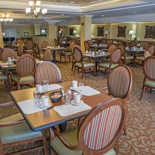 An elegant restaurant dining room with neatly arranged tables and chairs.