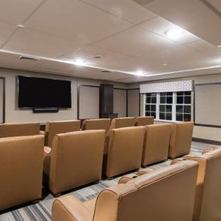 A cozy theater room with rows of comfortable seating and a large television screen.