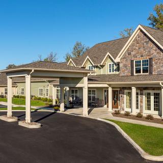 A large residential house with a covered driveway and well-maintained landscaping.
