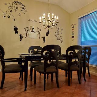 A cozy dining room with elegant decor and a chandelier.
