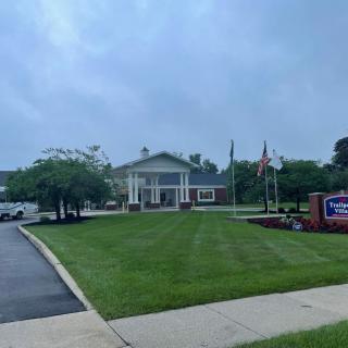 A building with a lawn and flags on an overcast day.
