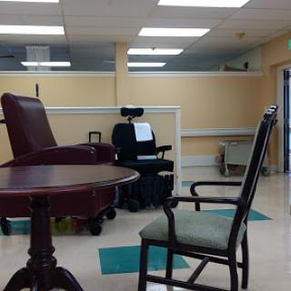 A waiting area in a medical facility featuring various chairs and a table.
