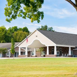 A modern building with a spacious lawn and clear sky.