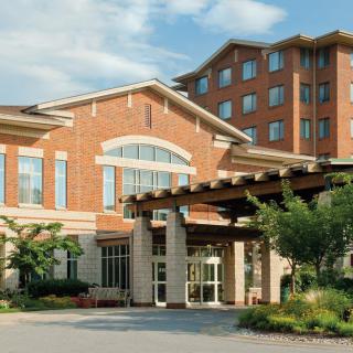 A brick hotel building with a prominent entrance and landscaped surroundings.