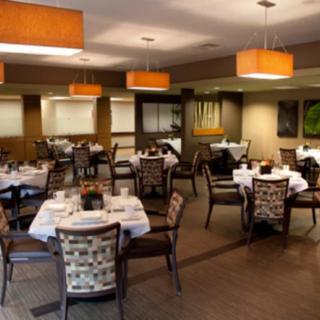 A spacious restaurant dining area with neatly arranged tables and elegant lighting.
