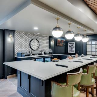 A modern home bar with stylish pendant lighting and a spacious countertop.