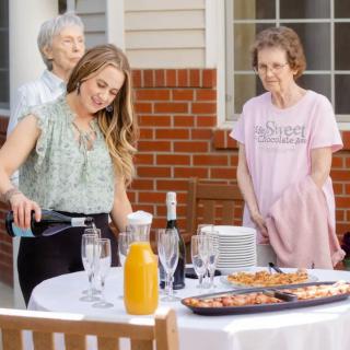 A group of people enjoying an outdoor gathering with food and drinks.