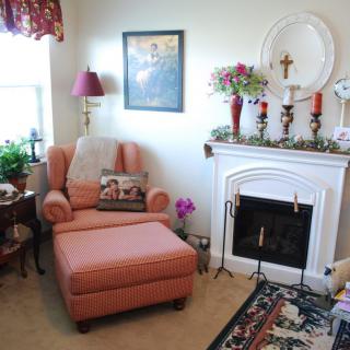 A cozy living room with a comfortable armchair and decorated fireplace.