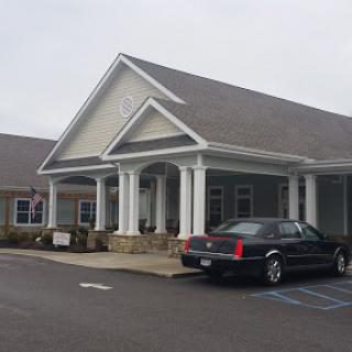 A charming building featuring a welcoming front entrance and a parked car.