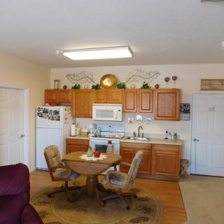 A cozy kitchen and dining area with wooden cabinets and a small round table.