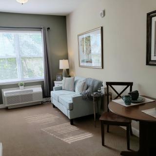 A cozy living room with a sofa, table, and large window.