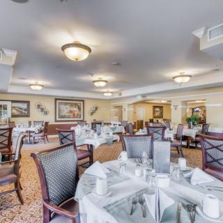 An elegantly set dining room with neatly arranged tables and chairs, ready for guests.