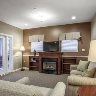 A cozy living room with a fireplace, television, and comfortable seating.
