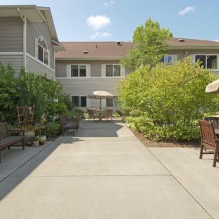 A courtyard with outdoor seating and lush greenery on a sunny day.