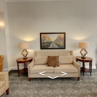 A cozy living room with a beige sofa, side tables with lamps, and a framed artwork above.