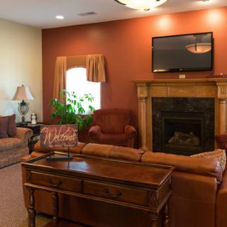 A cozy living room with a fireplace, sofa, and wall-mounted television.