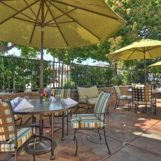 A cozy outdoor patio with tables, chairs, and umbrellas set up for dining.