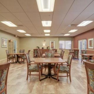 A well-lit dining area with neatly arranged tables and chairs.