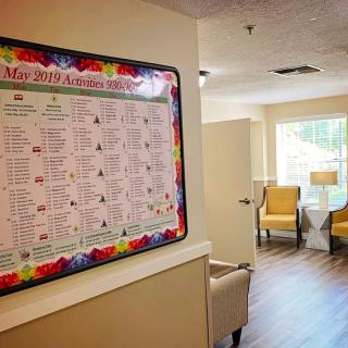 A cozy lobby with a colorful calendar on the wall and seating area.