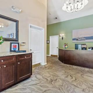 A well-lit office reception area featuring a desk, a chandelier, and decorative elements.