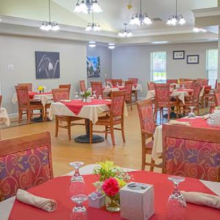 A well-arranged dining area featuring tables with red tablecloths and neatly set place settings.