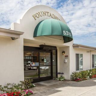 The entrance to a commercial building with an arched canopy and green awning.