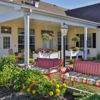 A cozy patio with colorful outdoor furniture and a vibrant garden.