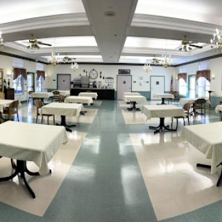 A spacious dining hall featuring neatly arranged tables and chairs, waiting to welcome guests.