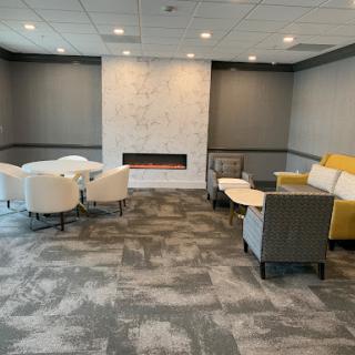 A modern lounge area featuring a cozy seating arrangement and a stylish fireplace.