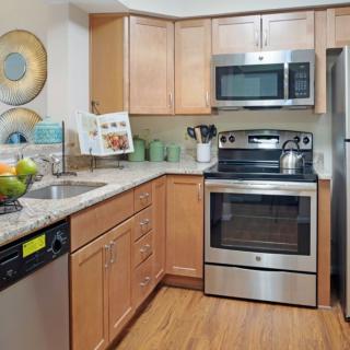 A modern kitchen with stainless steel appliances and wooden cabinets.