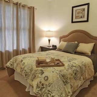Cozy bedroom with a neatly made bed and soft lighting.