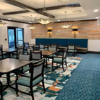 A modern dining area with tables, chairs, and stylish lighting fixtures.