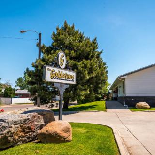 A roadside motel sign with a driveway leading to the building.